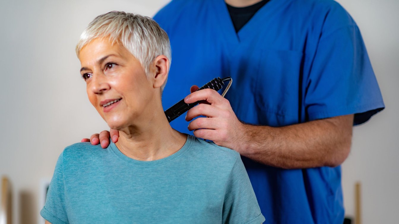 Physical therapist treating an older woman's neck at a Salem, Oregon clinic