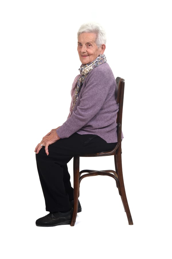 side-view-senir-woman-sitting-chair-smiling-looking-camera-white-background