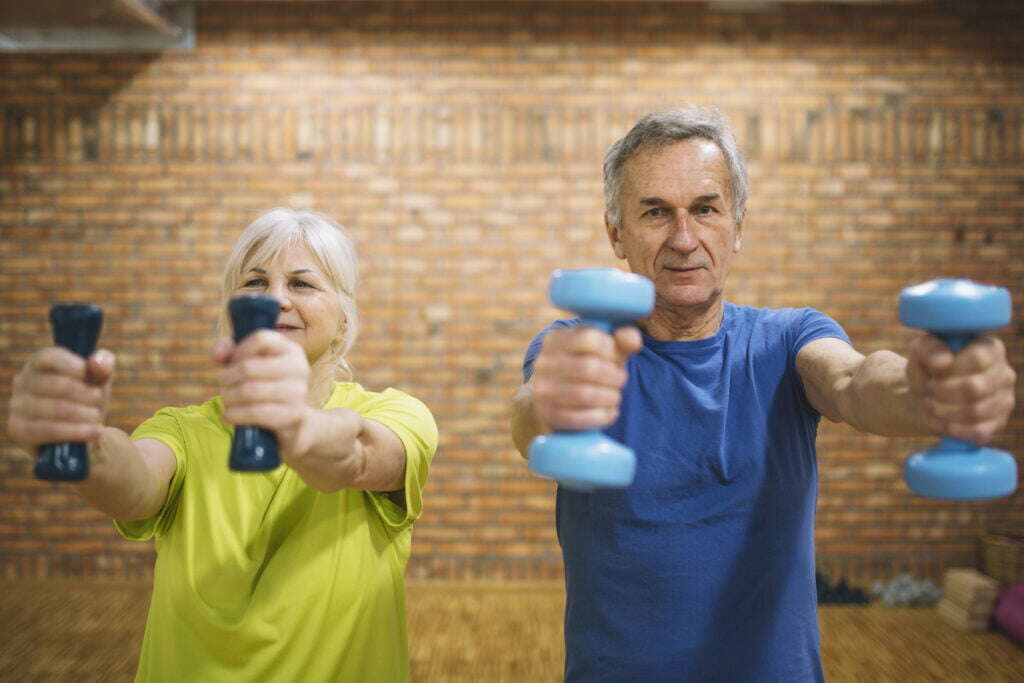 older adults exercising using dumbells